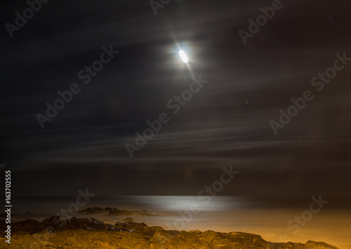 Long time exposure at night of the moon over the Wild Coast at the Indian Ocean in South Africa