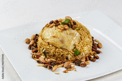 Traditional Middle Eastern fish and fried rice dish with fried pine nuts photo