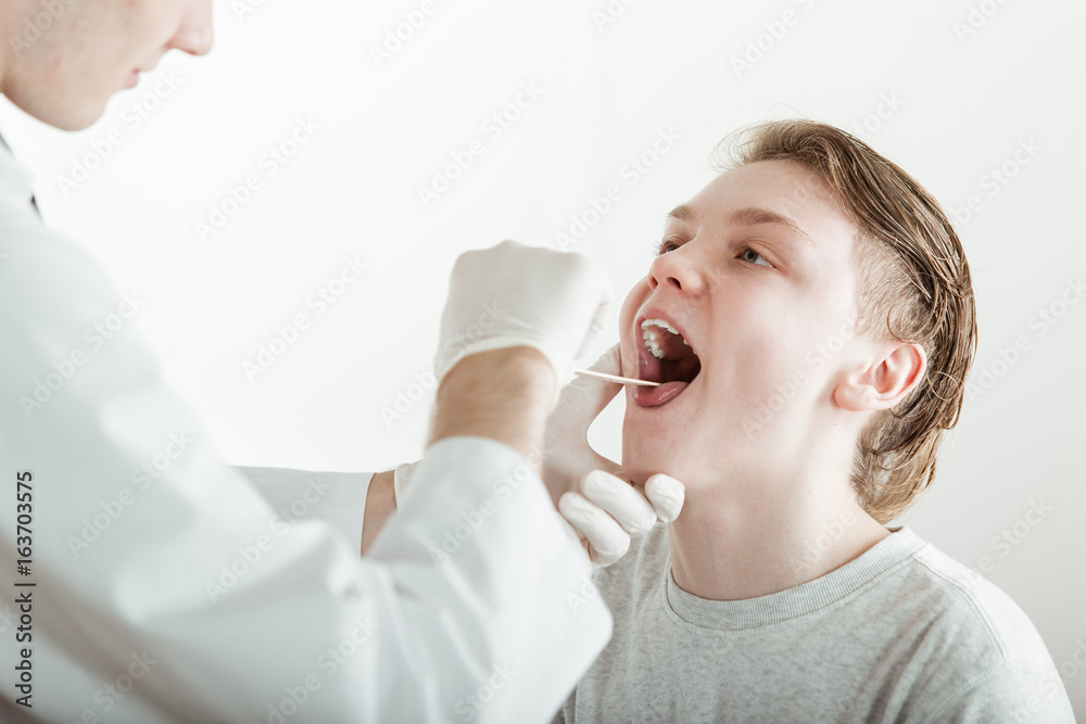 Teenage Boy Having Mouth Examined by Doctor