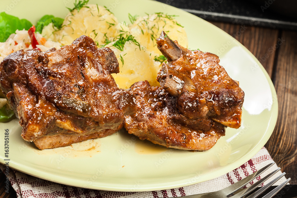 Pork spare ribs served with mashed potatoes and sauce Pork spare ribs served with mashed potatoes and sauce