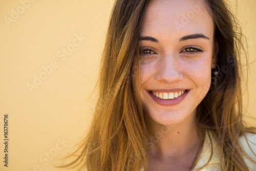 Close up of smiling woman against cream color background photo