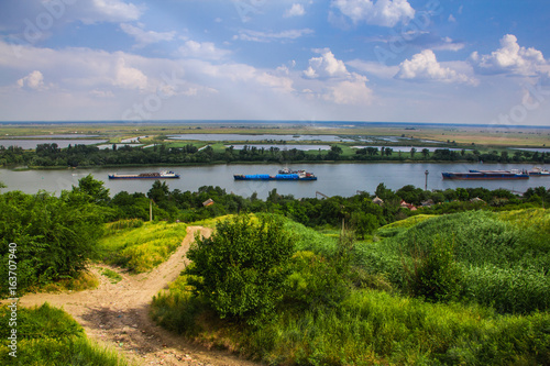 Summer landscape overlooking the river. Boats sail along the picturesque edge. The barge floats on the river. Quaint clouds in the sky. Rostov-na-Donu.