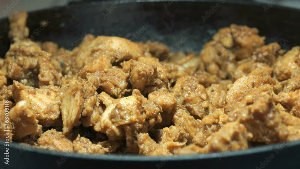 The process of frying the chopped chicken pieces for cooking kebabs on the cast iron skillet. Close-up The process of frying the chopped chicken pieces for cooking kebabs on the cast iron skillet. Close-up