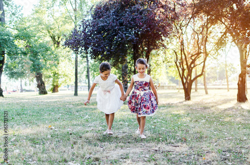 littl sisters running in nature photo