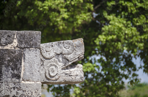 Serpent head of the Tzompantli at Chichen Itza, Mexico photo
