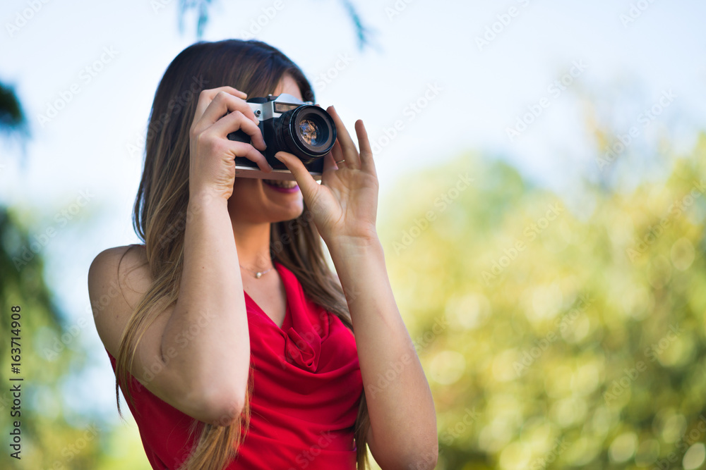 Smiling young woman holding a camera