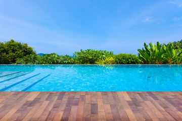 Swimming pool overlooking view andaman sea mountains and blue sky background,summer holiday background concept.