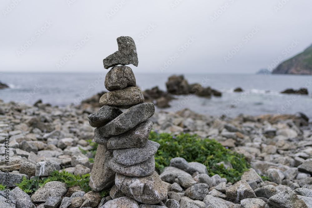 Cairn. Sculpture on the shore of the wild sea Cairn. Sculpture on the shore of the wild sea