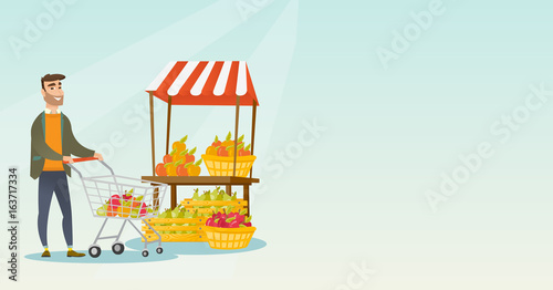 Young caucasian man pushing a supermarket cart.