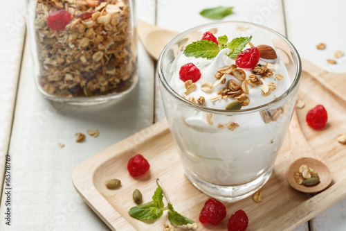 Homemade yogurt or sour cream in a glass on the white wooden table