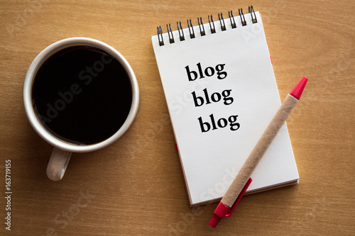 blog, blog, blog - blogging concept on a notebook with cup of coffee