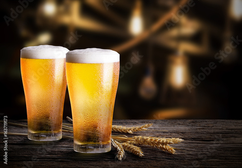 Foto Glasses of light beer with barley at bar
