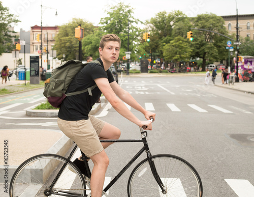 College student riding bike crossing the crosswalk in the city