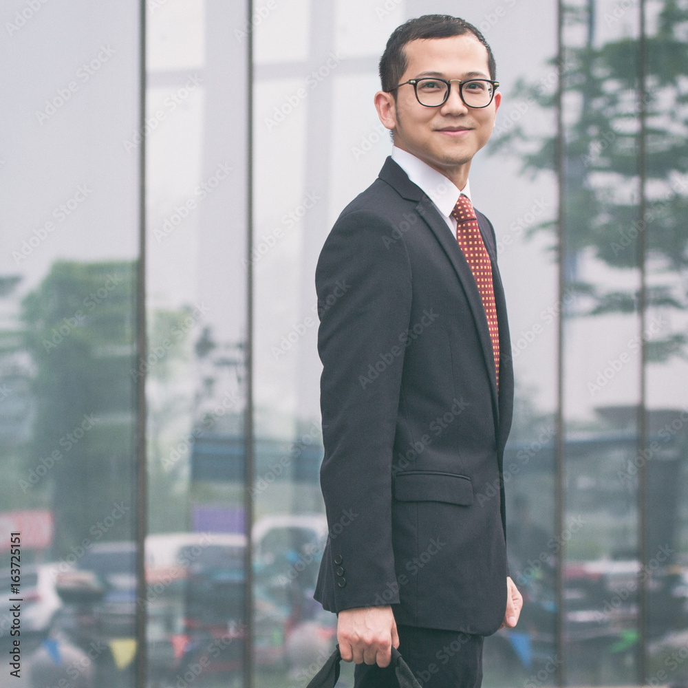 young businessman walking outside office young businessman walking outside office
