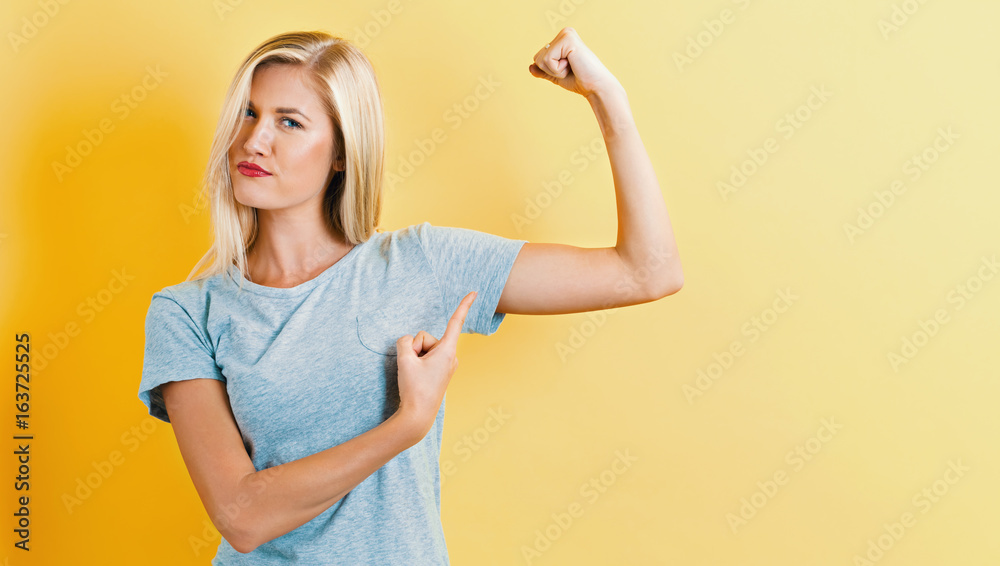 Powerful young woman on a yellow background Powerful young woman on a yellow background
