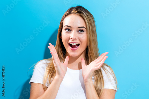 Surprised young woman posing on a blue background