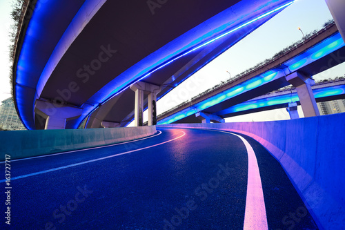 Принти на полотні Empty road floor with city viaduct bridge of neon lights night