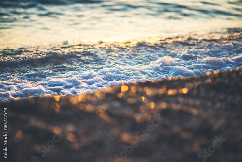 Sea waves and ripples at sunset background