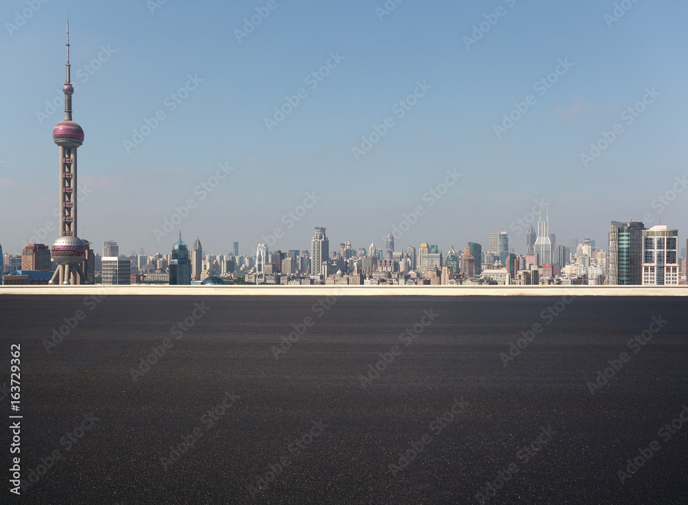 Fototapeta premium Empty road surface floor with city landmark buildings of Shanghai Skyline