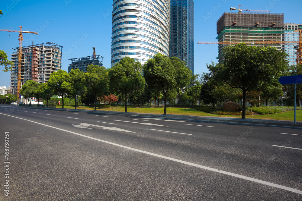 Empty road surface floor with buildings background Empty road surface floor with buildings background