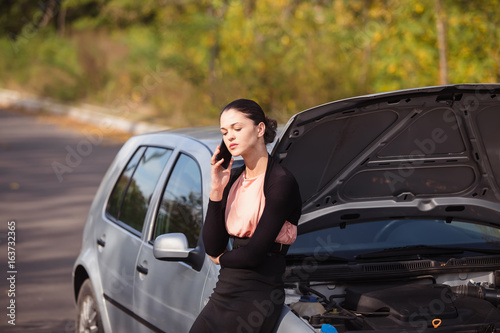 Young woman calling in evacuation service. Her car broke down on the road. © artem_goncharov