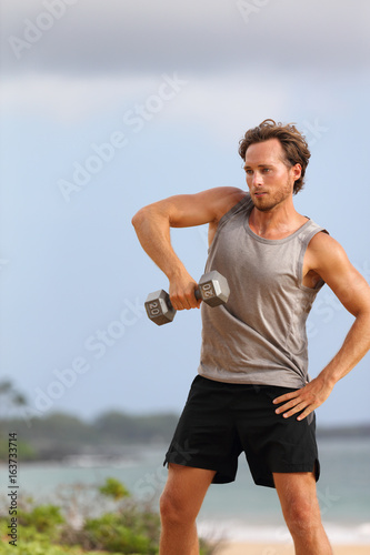 Dumbbell Snatch - man doing strength training fitness exercises with Dumbbells.