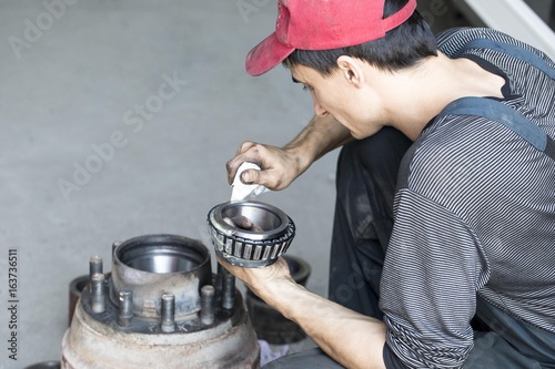 Auto mechanic makes the maintenance of the cargo trailer.
 photo