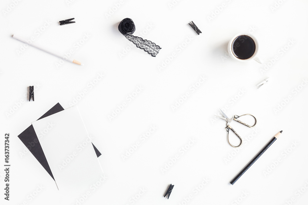 Stylish feminine workspace with paper blank, cup of coffee, accessories. Home office desk. Flat lay, top view Stylish feminine workspace with paper blank, cup of coffee, accessories. Home office desk. Flat lay, top view
