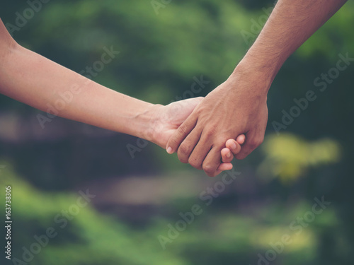Image of couple holding hands together. © Johnstocker