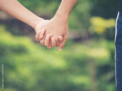 Image of couple holding hands together. © Johnstocker