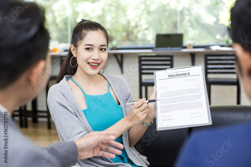 Asian woman try to present detail of insurance paper to customer at cafe. Woman in presentation concept. 20-30 years old. photo