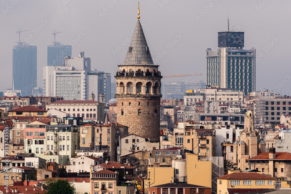 ISTANBUL,TURKEY-MAY 01,2017:View of galata tower  from courtyard of Suleymaniye Mosque through domes of madrasas, Istanbul, Turkey