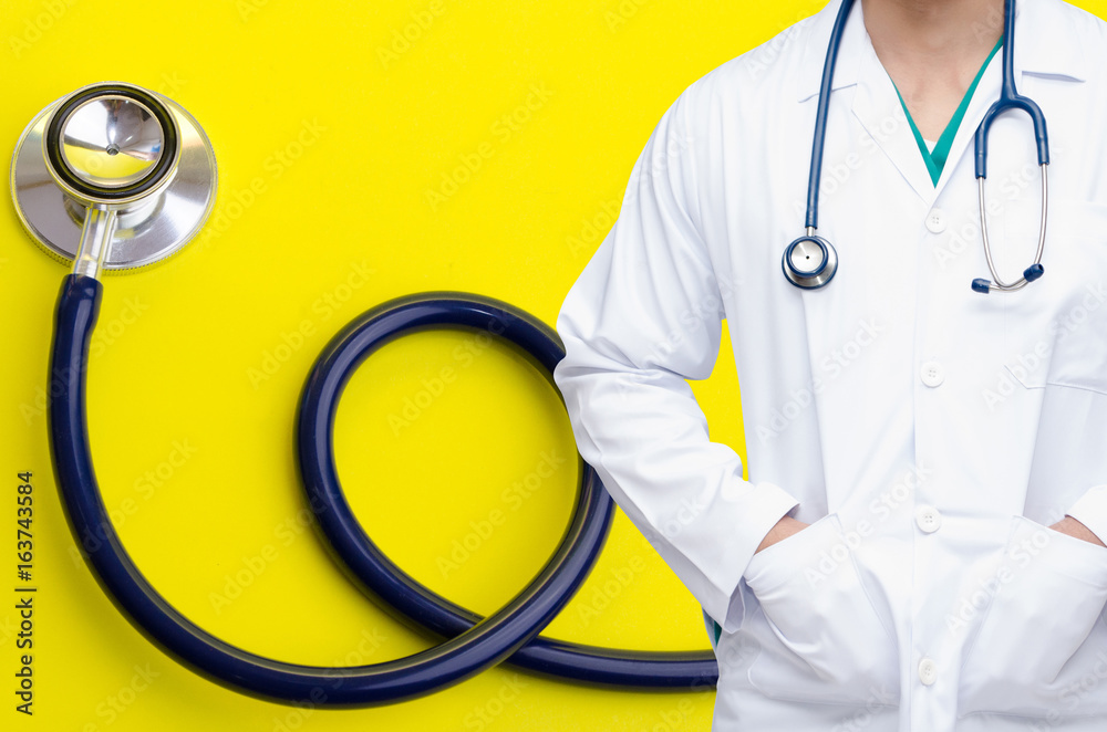 smart doctor with a stethoscope around his neck with stethoscope on yellow background, heart health care and medical technology concept, selective focus. smart doctor with a stethoscope around his neck with stethoscope on yellow background, heart health care and medical technology concept, selective focus.