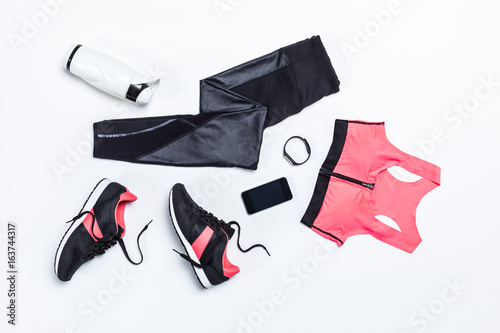 Fototapeta Naklejka Na Ścianę i Meble -  top view of sportswear, sportive water bottle for training and digital devices isolated on white