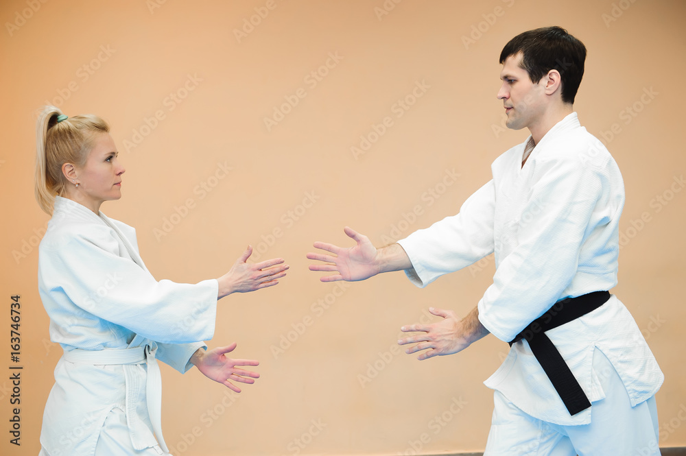 Man and woman fighting at Aikido training in martial arts school Man and woman fighting at Aikido training in martial arts school