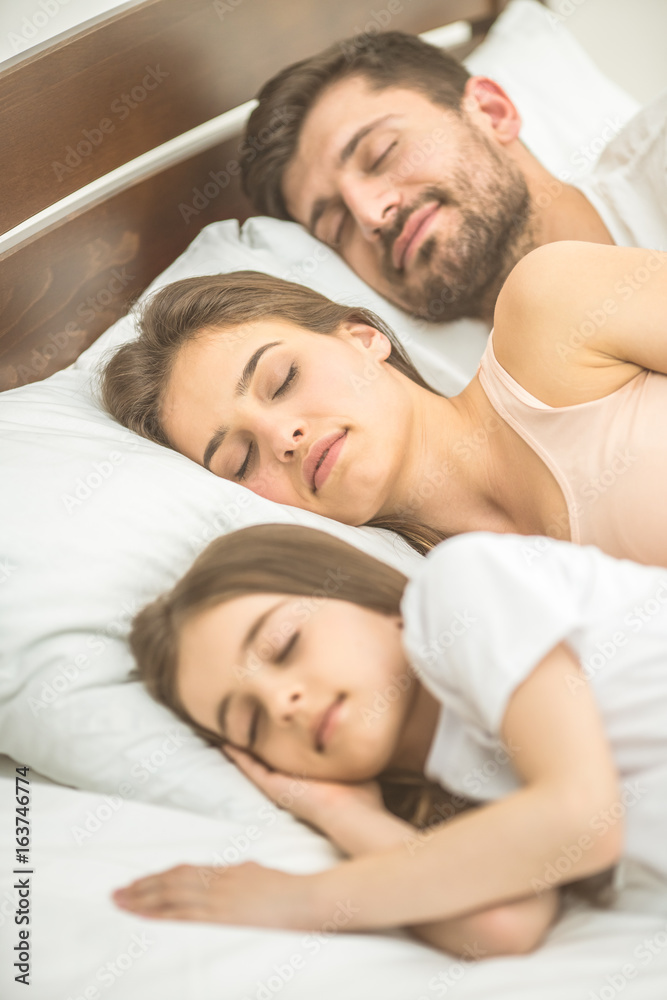 The family sleeping on the comfortable bed The family sleeping on the comfortable bed