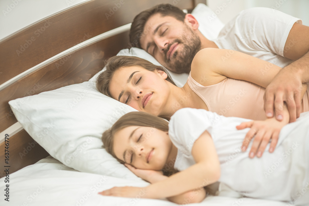 The happy family sleeping on the comfortable bed The happy family sleeping on the comfortable bed