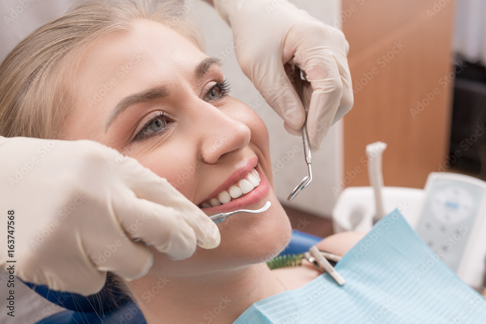 Close-up of female with open mouth during oral checkup at the dentist.Dentist Close-up of female with open mouth during oral checkup at the dentist.Dentist