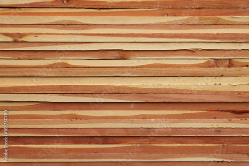 Pattern of stacked wooden plank boards at sawmill lumberyard