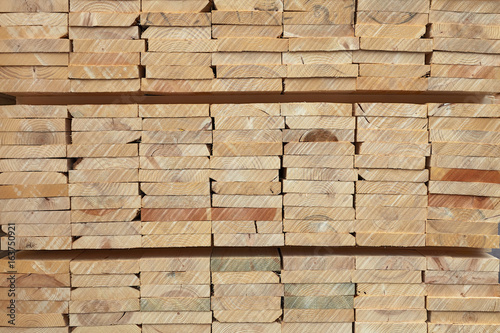 Pattern of stacked rectangular wooden beam timber at sawmill lumberyard
