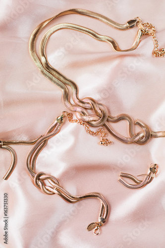 female Golden jewelry in pink background