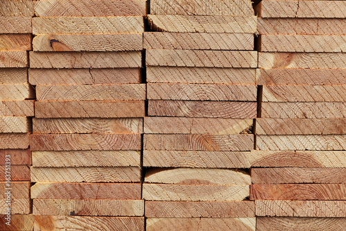 Pattern of stacked rectangular wooden beam timber at sawmill lumberyard