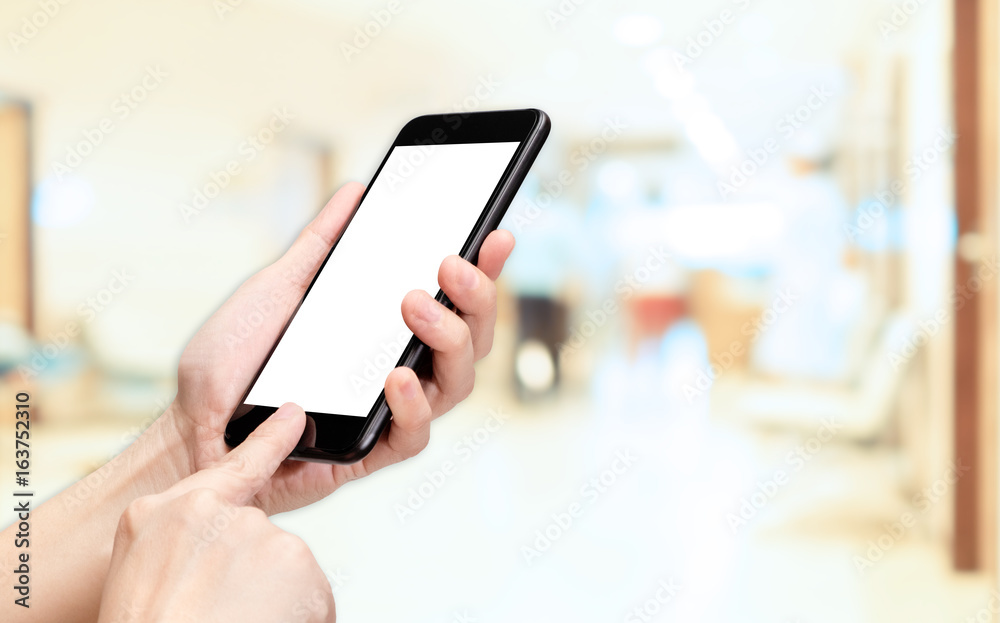 Hand click mobile phone with blur patient at hospital background bokeh light,White screen mock up template for adding your design or your text