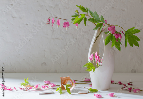 pink flowers in vase on old white background photo