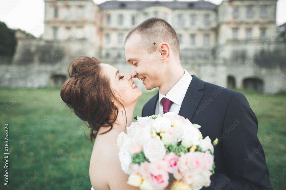 Portrait of happy wedding couple with head to head near castle Portrait of happy wedding couple with head to head near castle