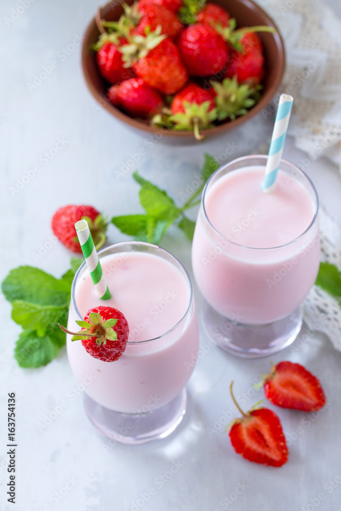 Freshly squeezed strawberry berry cocktail in a glass jar on a gray stone or slate background. Superfoods and health or detox diet nutrition concept. Freshly squeezed strawberry berry cocktail in a glass jar on a gray stone or slate background. Superfoods and health or detox diet nutrition concept.