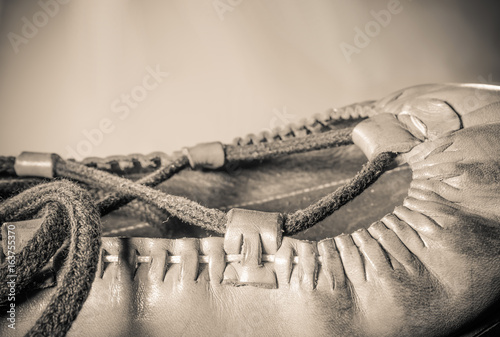 beautiful basque dancing leather shoe abarka close up on light brown background isolated top view in sepia vintage retro macro  photo