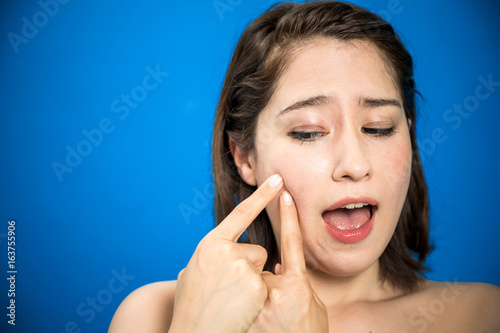 Wallpaper Mural young woman who checks her skin. acne treatment. Torontodigital.ca