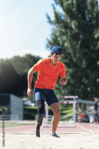 Disabled man athlete jumping with leg prosthesis. Paralympic Sport Concept.