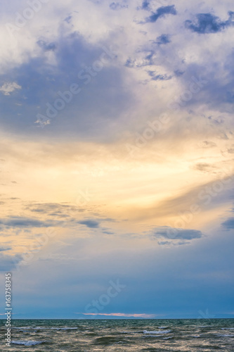 bird flying over surface of green sea waves with mountains on background  